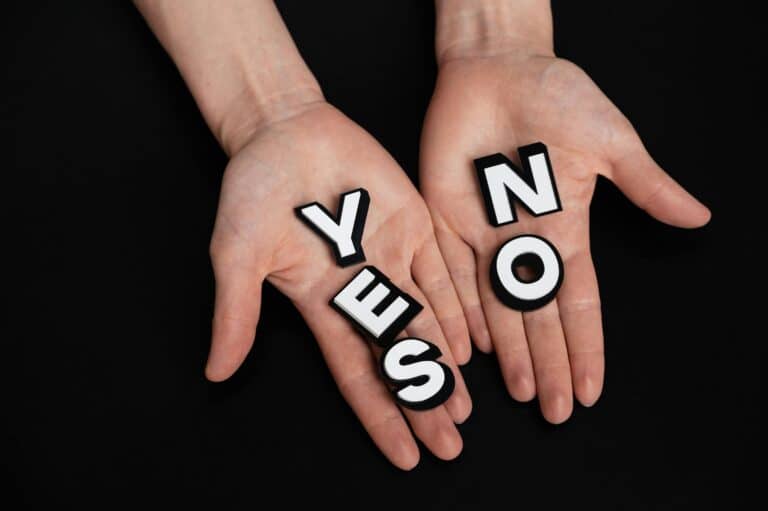 a pair of hands holding the words yes and no